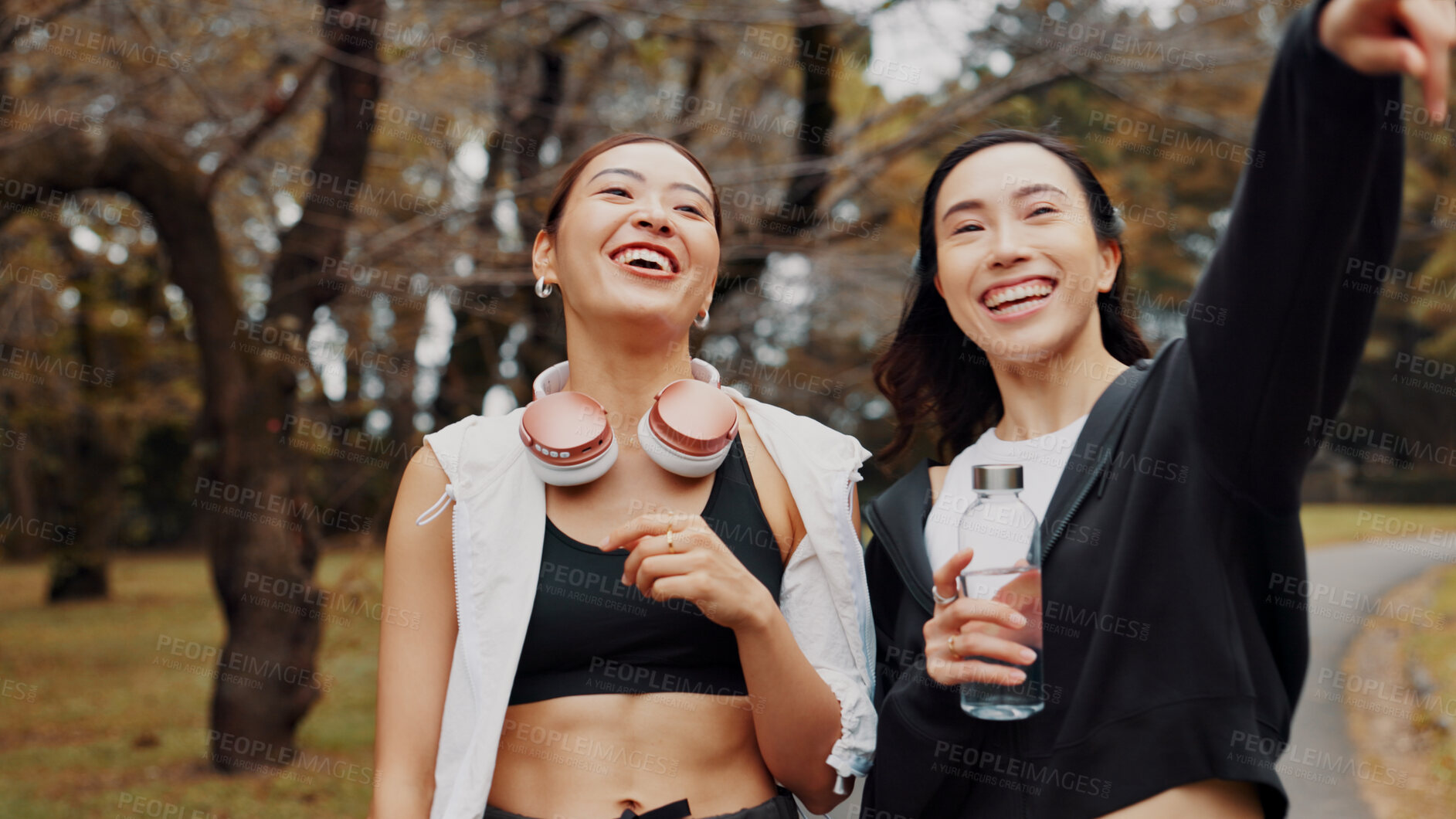 Buy stock photo Women, fitness and smile with point in park searching for exercise program with health. Friends, headphones and athlete people with workout, routine and outdoor in Japan nature for training together