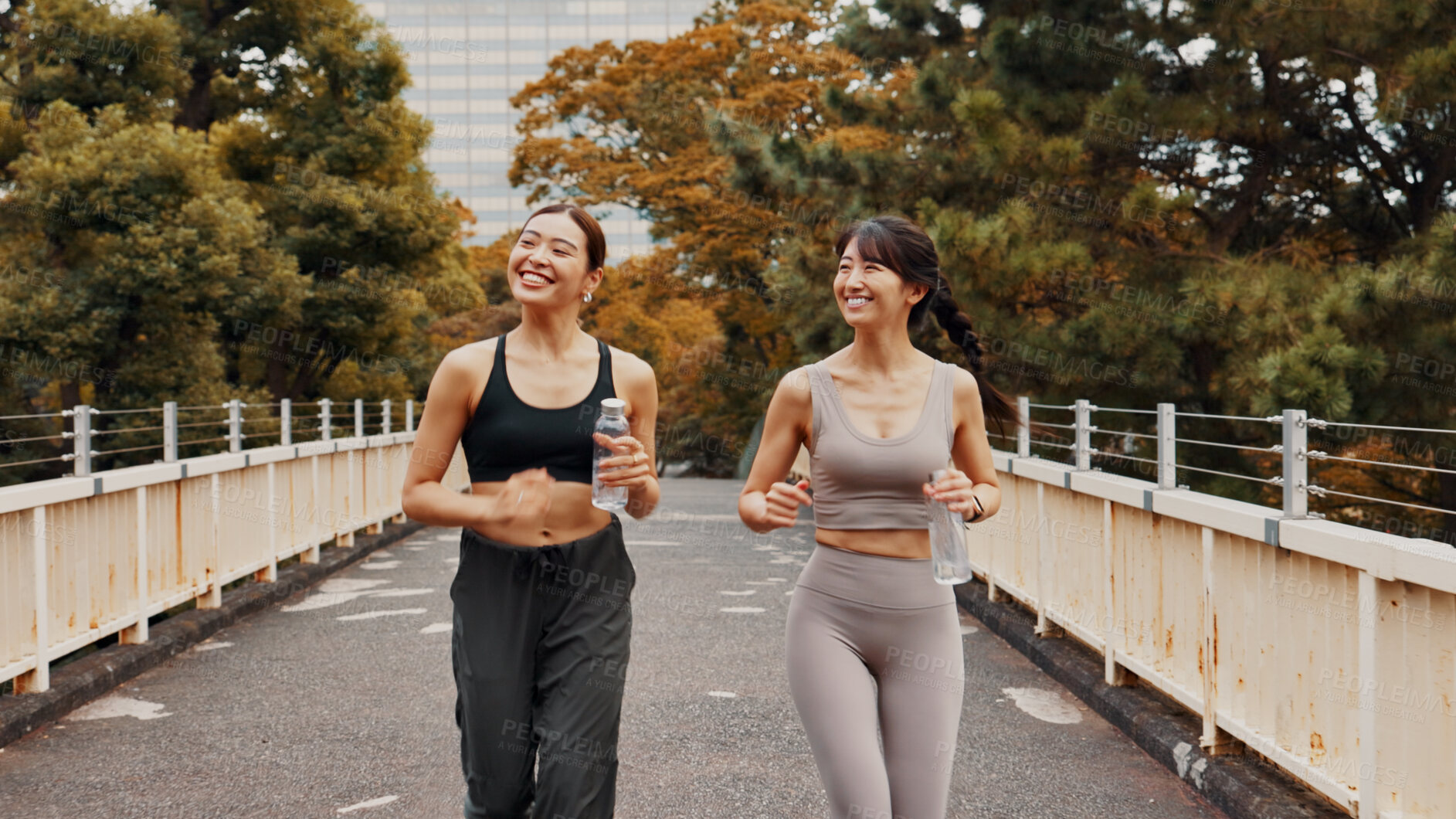 Buy stock photo Running, fitness and exercise for women, bridge and routine in morning, smile and bonding with conversation. Outdoor, workout and Asian people with bottle of water, happy and wellness for friends