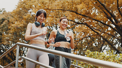 Buy stock photo Running, exercise and fitness for women, steps and friends with water, smile and active in morning. Outdoor, personal trainer and routine with Asian person, stairs and practice for marathon in Japan