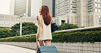 City, walking and back of woman with suitcase for travel, commute and journey in urban town. Professional, explore and business person with luggage for work trip, destination and career in Japan