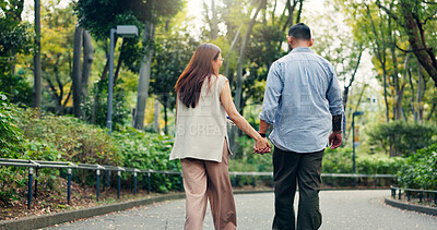 Buy stock photo Couple, holding hands and happy walking in park, talking and funny joke on honeymoon vacation. People, security and outdoor back support on holiday in Japan, travel together and explore relationship