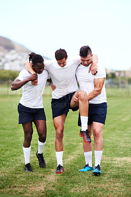 Buy stock photo Men, sport and team with injury on grass field for emergency, medical attention or accident in nature. Male people, athletes or rugby players with support or aid for knee pain or sore leg at game