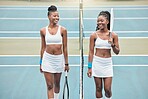 Smiling tennis players holding their rackets on the club court. Two young friends bonding and talking after a practice tennis match. Friends playing tennis as a hobby on the weekend