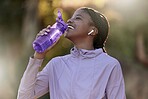 Exercise, black woman and drinking water for fitness, wellness and health outdoor to relax. Fitness, young female Nigerian and athlete hydration, liquid for break and training for workout and airpods