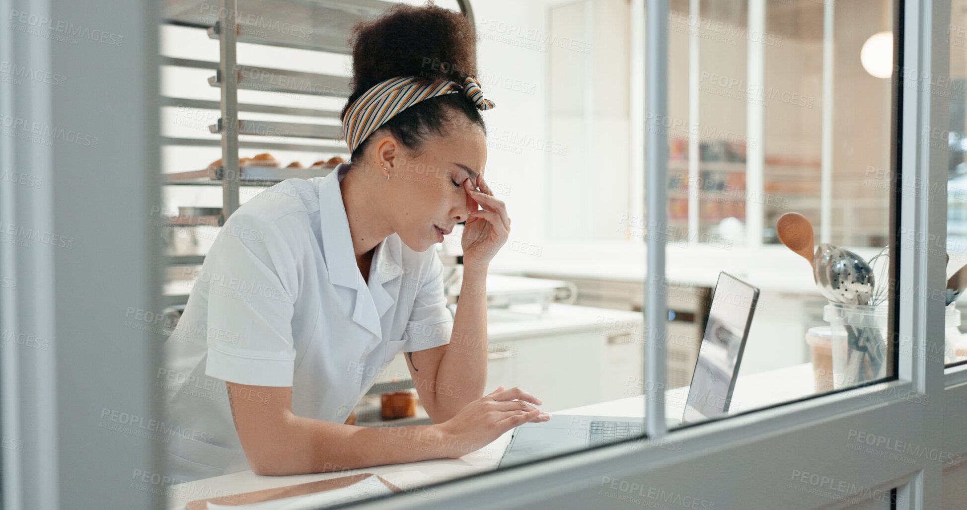 Buy stock photo Stress, tired and laptop with chef in kitchen for online recipe, restaurant review and research at night. Fatigue, menu planning and frustrated with person in coffee shop for social media and burnout