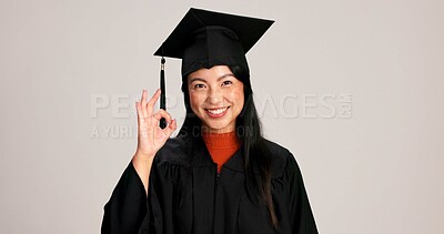 Buy stock photo Ok, graduation and smile with portrait of asian woman in studio for success, college degree or award. Achievement, education and university student with person on white background for mockup space