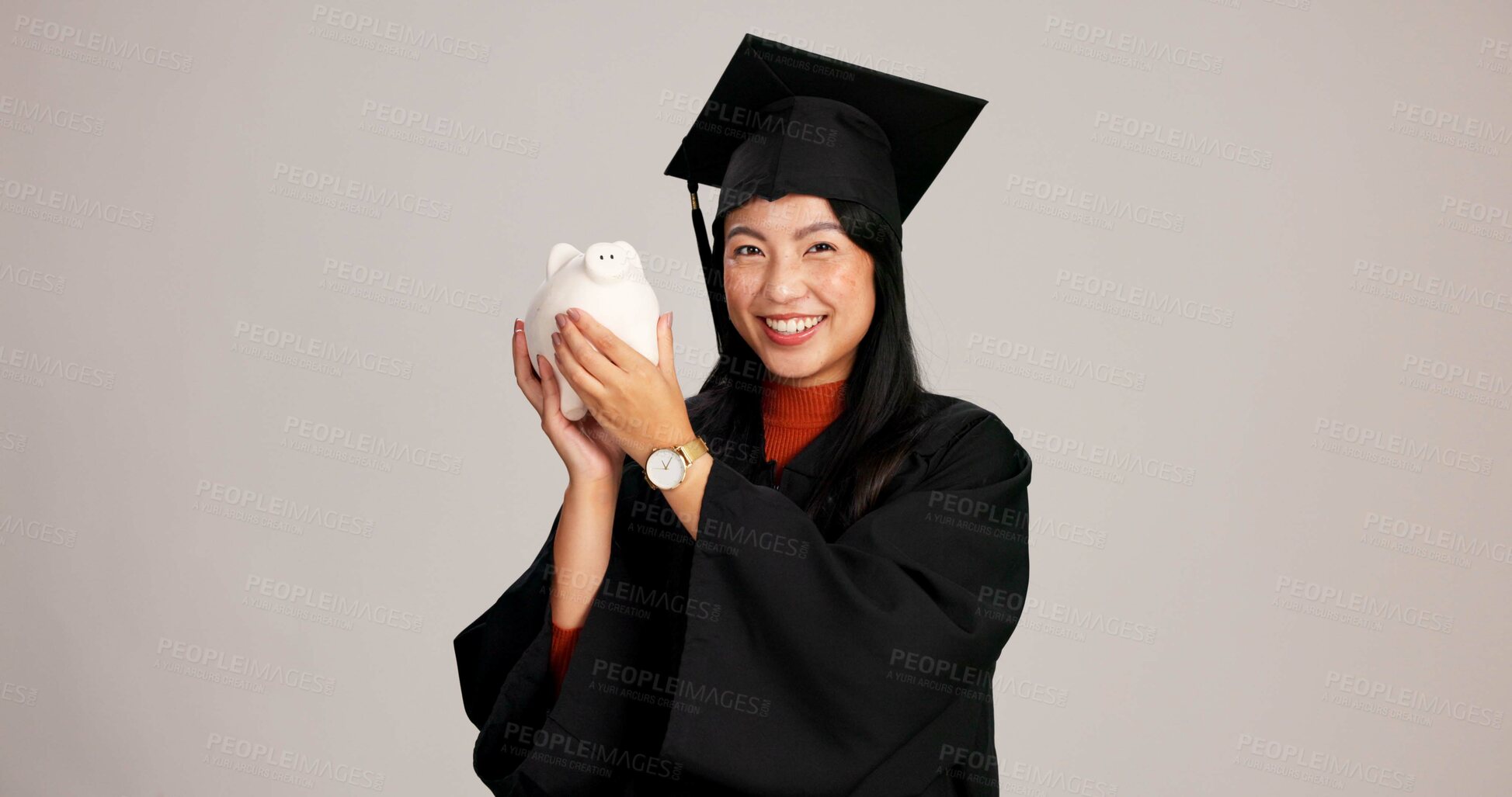 Buy stock photo Woman, graduation and happy with piggy bank in studio background for savings, financial aid or investment. Asian person, portrait and smile with money or funds for tuition fees and higher education