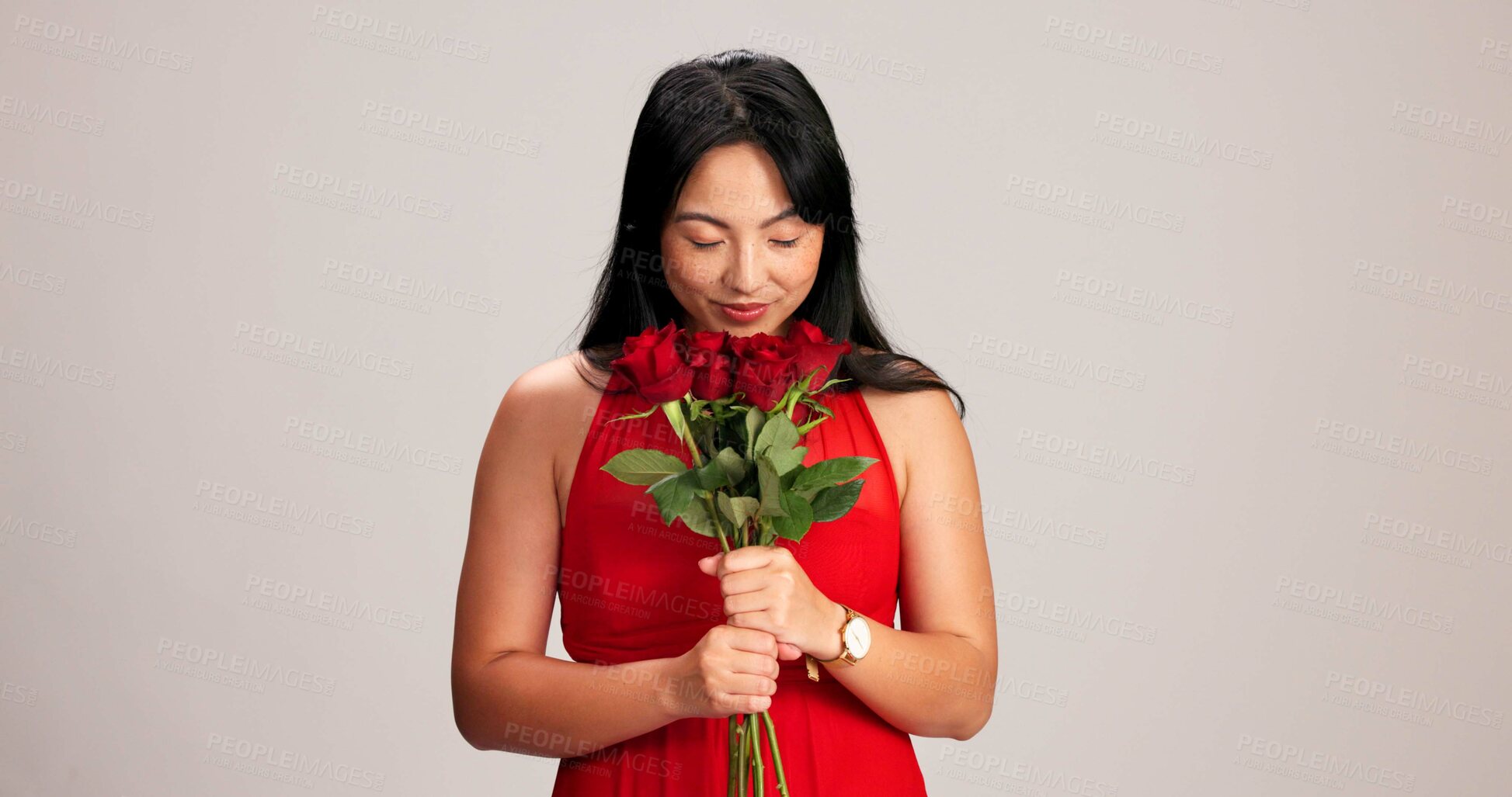 Buy stock photo Woman, studio background and smelling roses for love, care and valentines day celebration in Japan. Japanese person, romance and eyes closed in red dress with bouquet of flower as anniversary gift