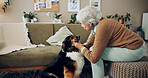 Senior woman, retirement home and dog with affection, care and bonding for love, companion and play. Female person, pet and emotional support in living room for happiness, joy and kindness as owner