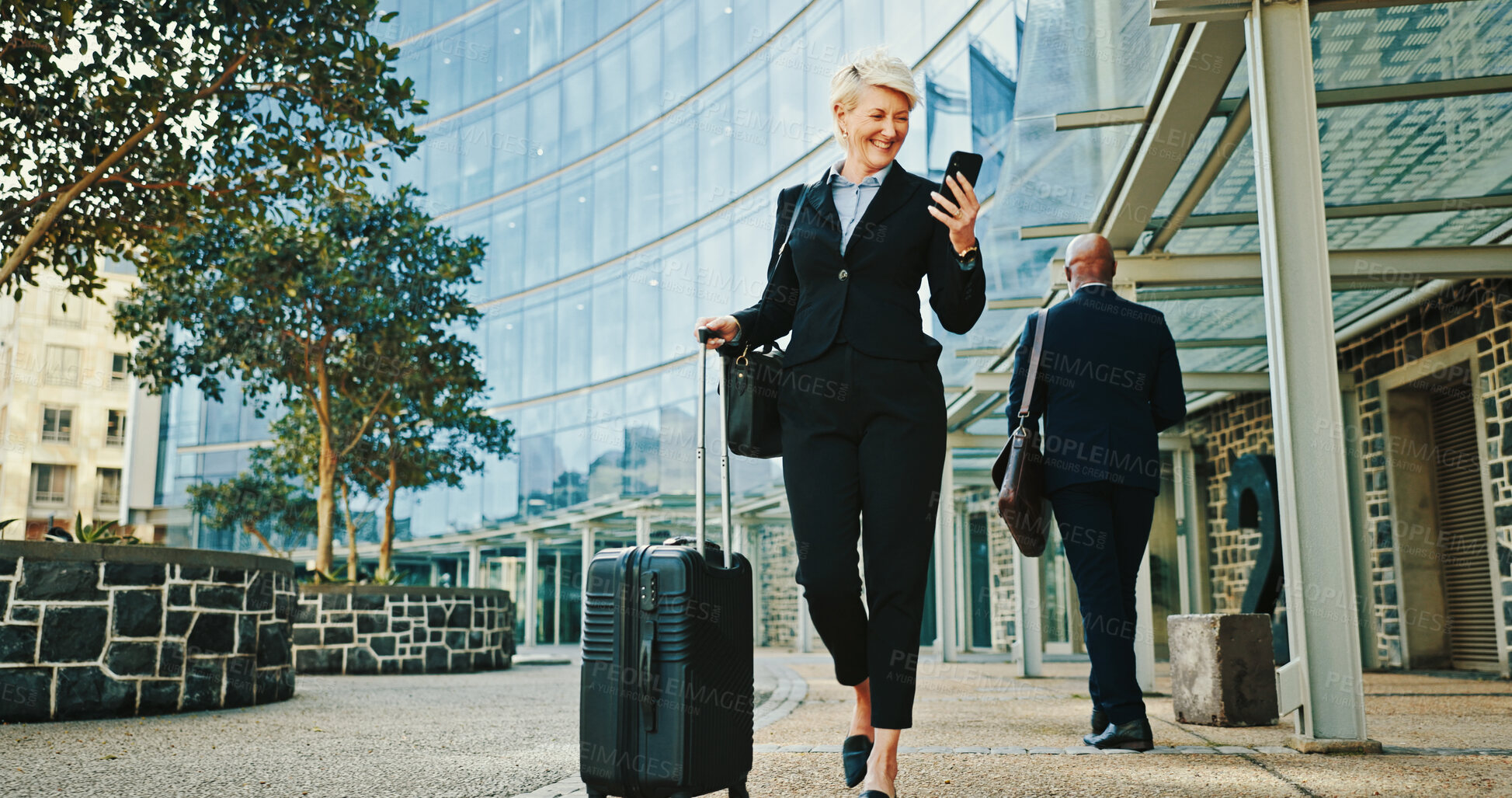 Buy stock photo Phone, businesswoman and travel with luggage in city for journey, booking flight or walking. Mobile, trip or mature professional with suitcase at hotel, commute or happy manager reading email online