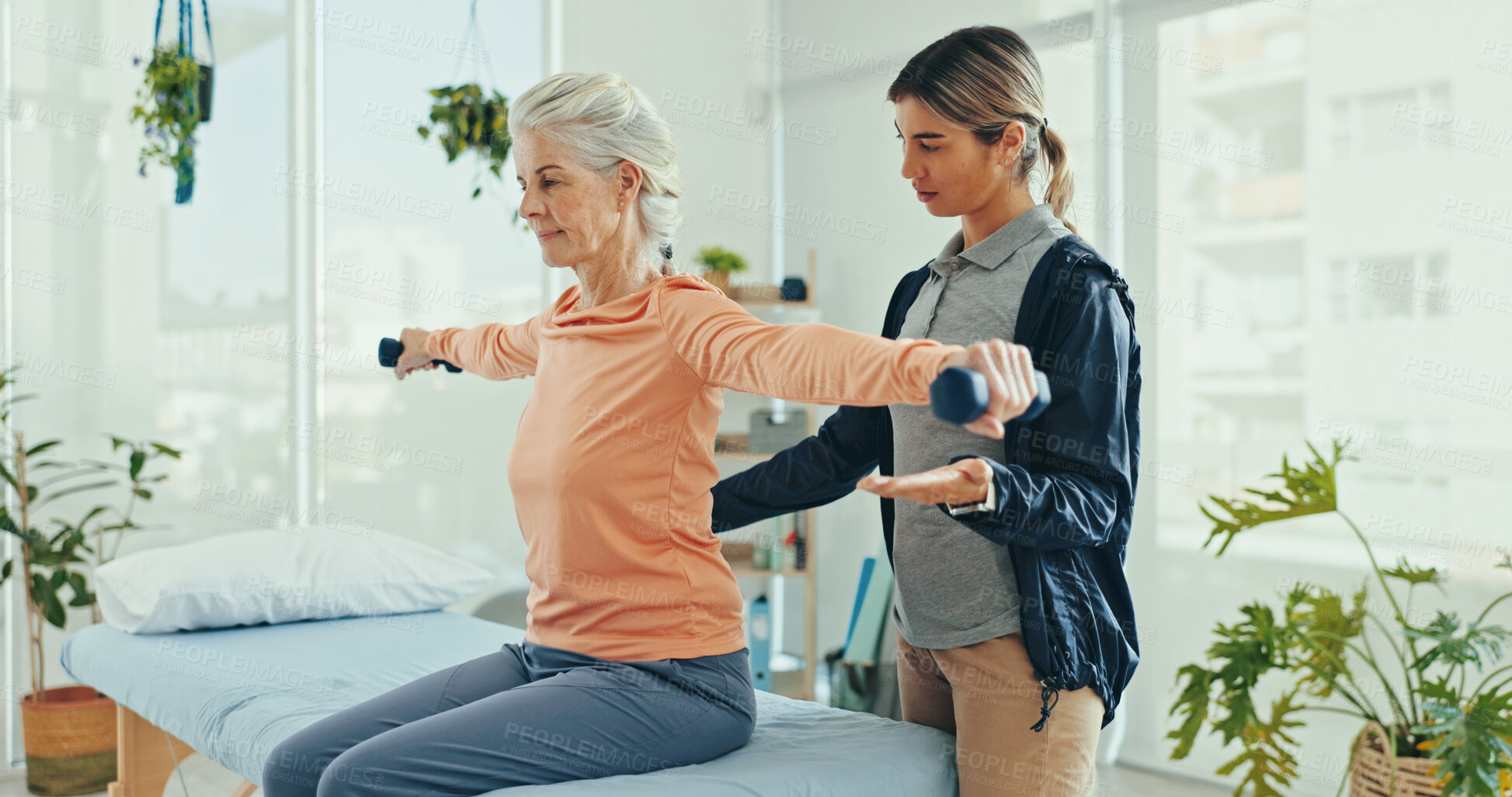 Buy stock photo Senior woman, physiotherapy and dumbbells for recovery for injury with guide, helping hand or support. People, wellness and exercise for muscle, progress or weightlifting for rehabilitation at clinic