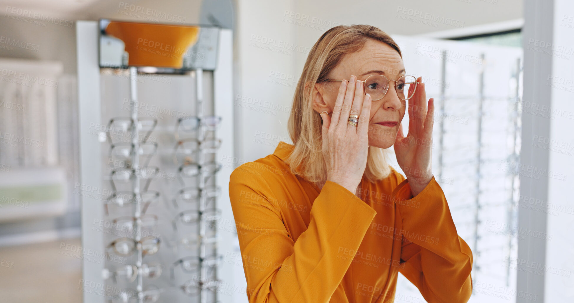 Buy stock photo Woman, glasses and shopping with check, mirror or clinic for healthy vision with optometry service for wellness. Mature person, client or customer for decision, prescription eyewear or frame at store