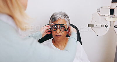Buy stock photo Doctor, optometry and woman with trial lens for eye care, consultation or hands in clinic for health exam. Ophthalmologist, test and senior patient with frame for vision check, wellness or correction