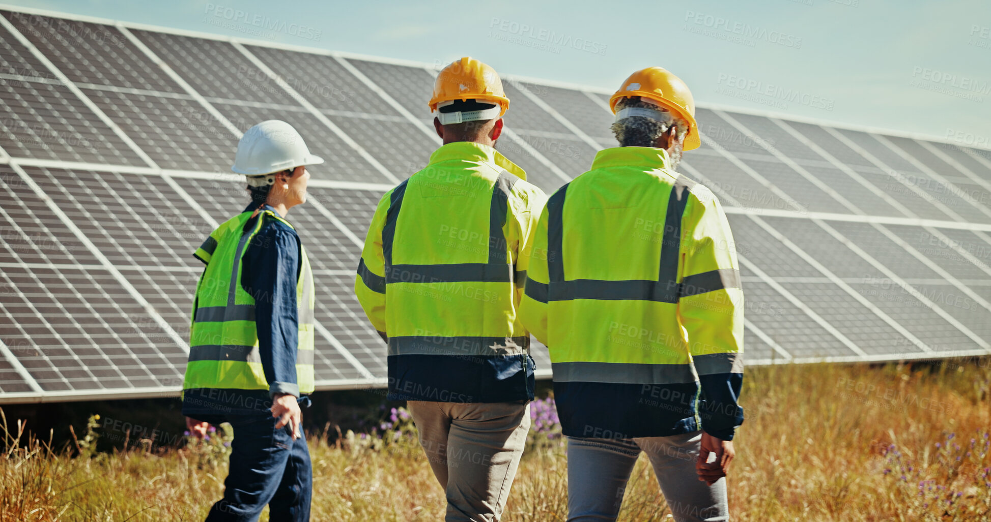 Buy stock photo Solar panel, walking and back with people, inspection and cooperation for renewable energy project. Group, climate change and employees in field, sustainability and eco friendly with quality control