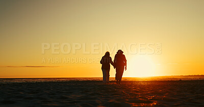 Buy stock photo Back, sunset and walking with couple on beach together for romantic holiday, travel or vacation. Holding hands, silhouette and sky with people on coast at ocean or sea for dating, getaway or love