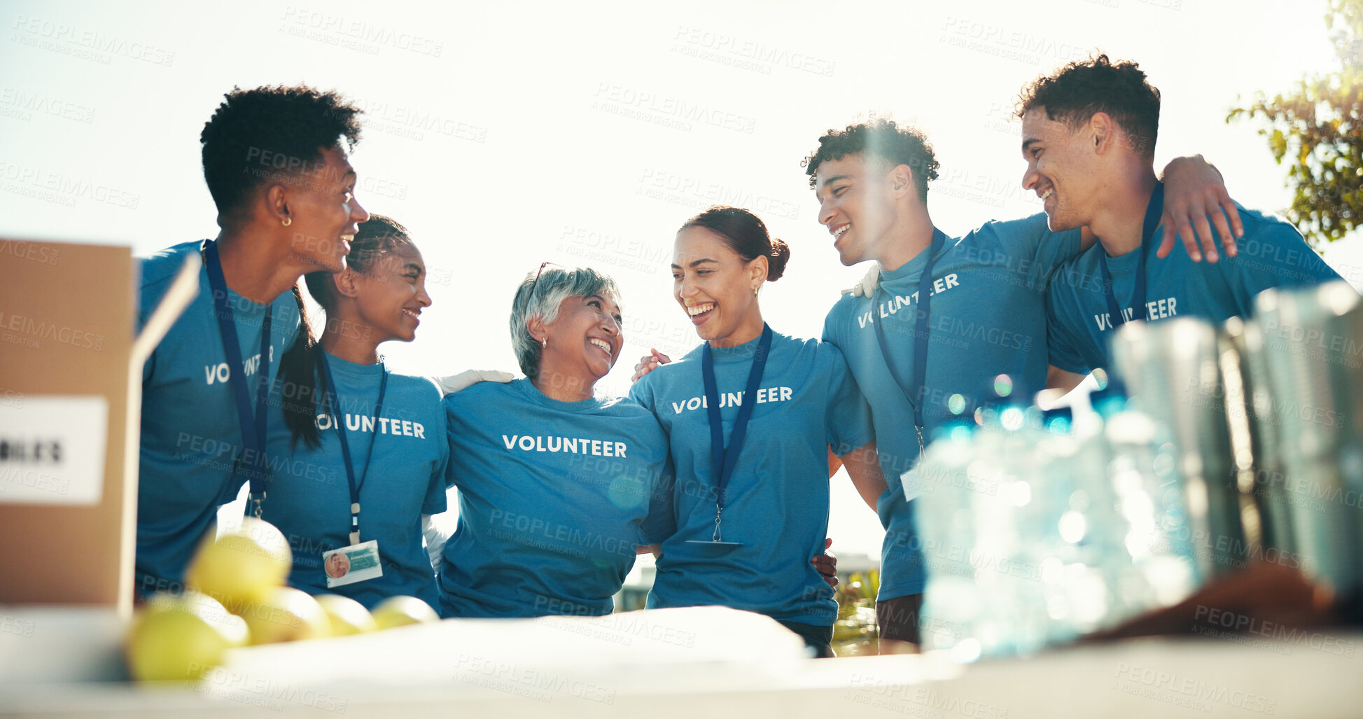 Buy stock photo Unity, hug and group of volunteers, smile and proud of organization, care and communication for nonprofit. Outdoor, community service and people with kindness for ngo, volunteering and fundraiser