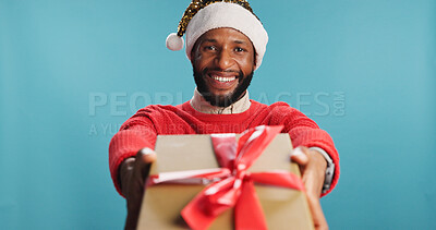 Buy stock photo Portrait, black man and present for Christmas in studio of festive celebration, surprise gift and Santa Claus. Smile, male person and box for giveaway announcement, holiday reward and blue background
