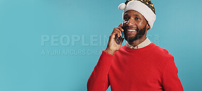 Buy stock photo Christmas, man and phone call in studio with smile, good news and wishes for festive season in banner. Person, happy and Santa hat on blue background with contact, connection and chat at mockup space