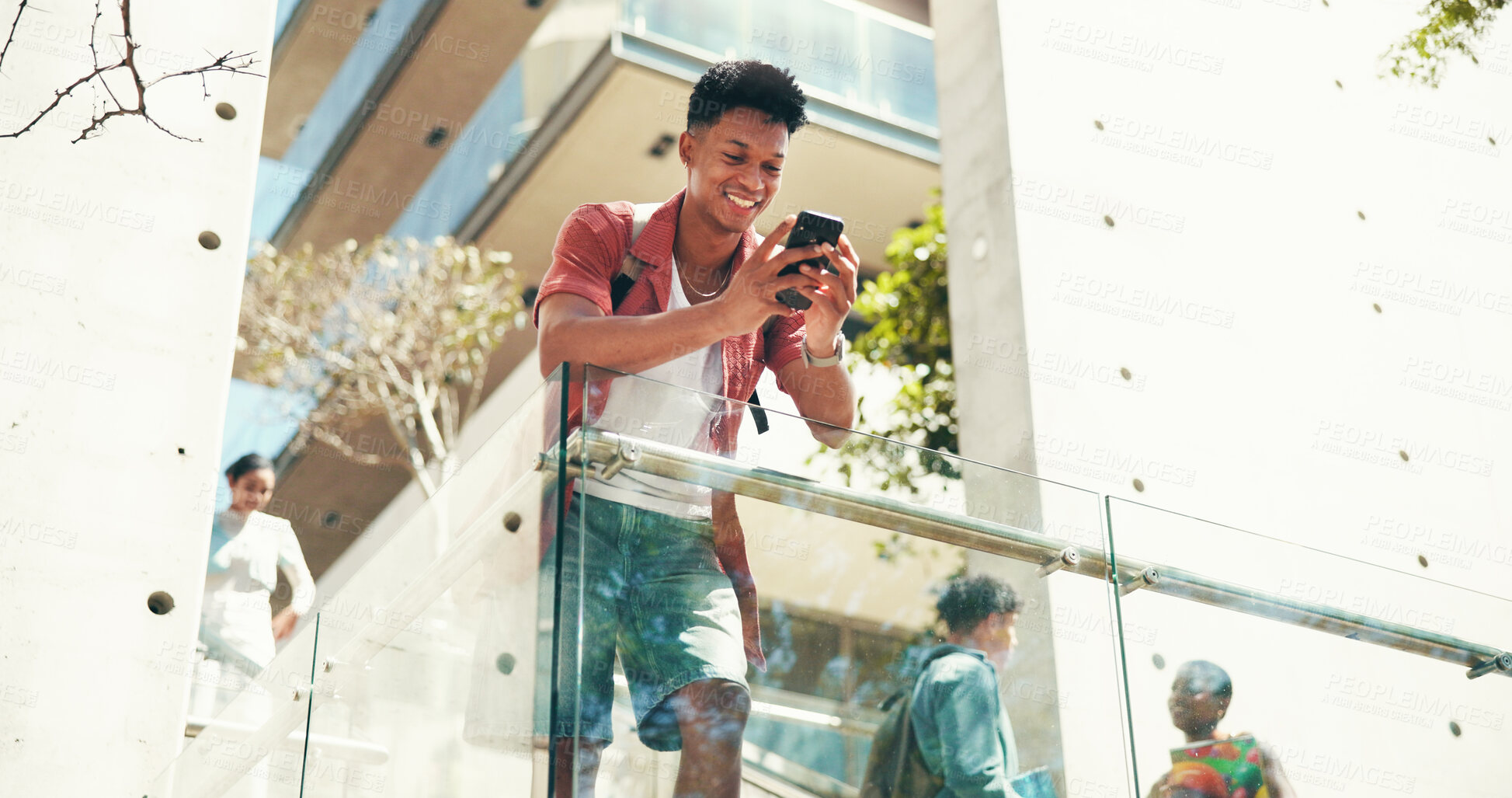 Buy stock photo Phone, happy student and man at university outdoor for schedule, learning or online education. Smile, mobile and person at college campus to check test results, research or reading text in low angle