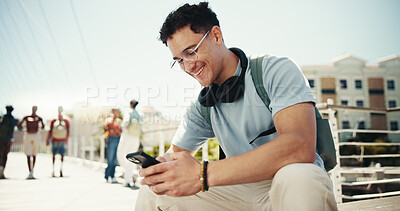 Buy stock photo Mobile, happy student and man at college outdoor for schedule, learning or online education. Relax, phone and person at university campus to check test results, notification and typing text message