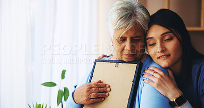 Buy stock photo Senior woman, nurse and photo with support for grief, compassion and empathy with loss in home. Elderly care, caregiver and person hug picture frame for mourning, memory and remember in retirement