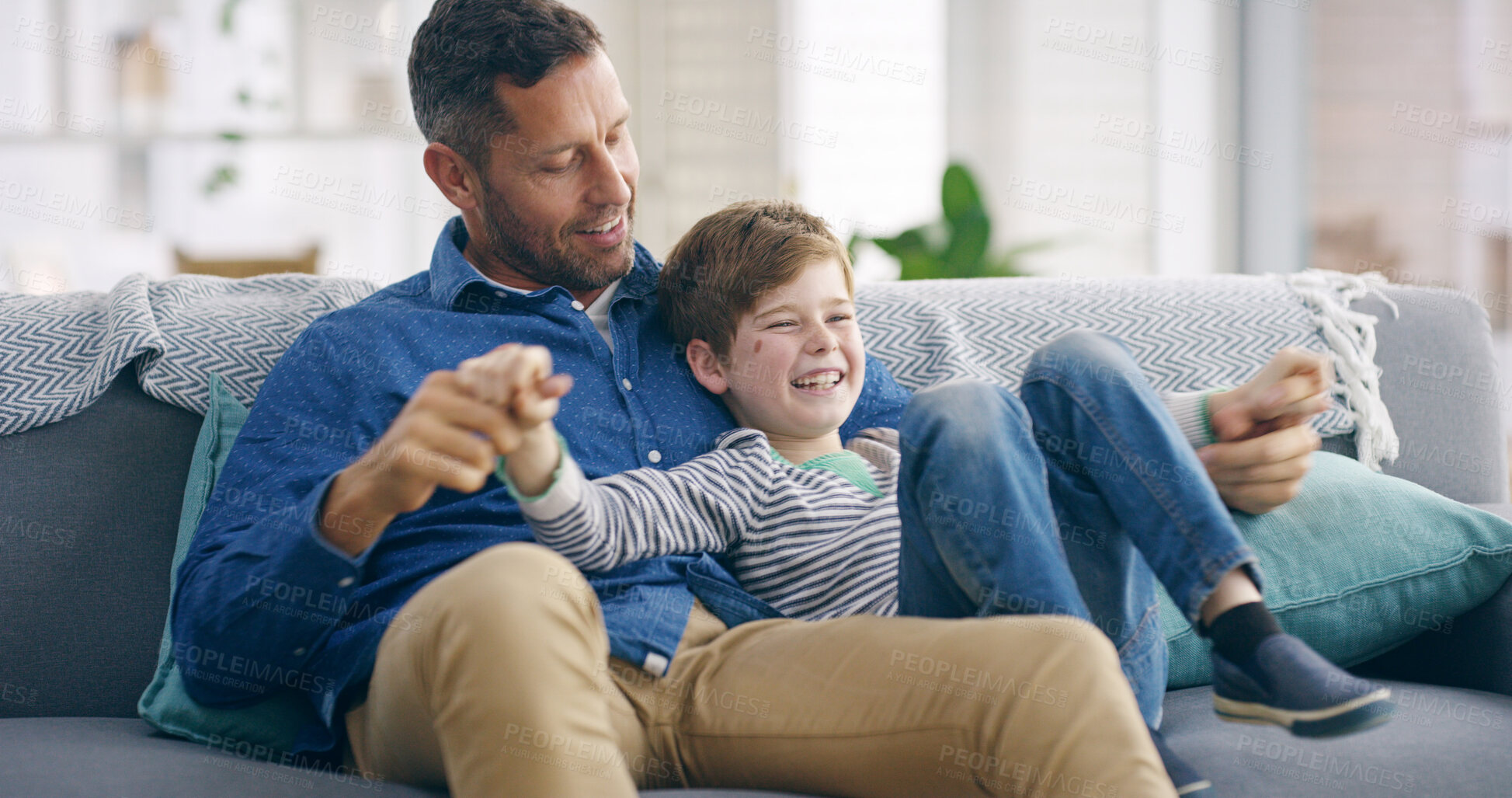 Buy stock photo Playful, father and child on sofa for laughing, connection and bonding together with funny conversation. Happy people, dad and boy at home for relax, healthy relationship or parenthood in living room