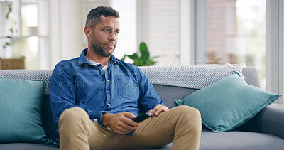 Buy stock photo Man, watching tv and remote on sofa, bored and channel surfing in living room, lonely and reflection in morning. Person, television and depressed with memory, anxiety or social isolation at apartment