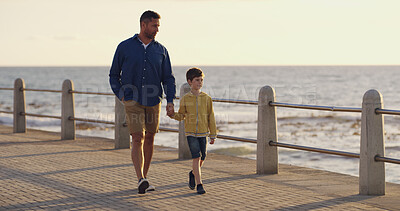Buy stock photo Father, son and holding hands at sea on holiday, walking and outdoor for bonding with daddy. Boy, child and papa for vacation security on promenade, together and ocean for love or connect on trip