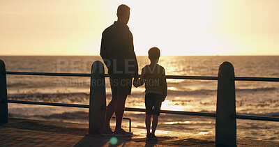 Buy stock photo Father, son and holding hands at sunset on beach, walking and outdoor for bonding with daddy. Back, child and papa for sightseeing on promenade, together and ocean view for love or connect on trip