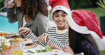 Christmas, children and eating lunch by home for festive celebration, bonding or conversation outdoor. Food, family or happy people on patio for holiday dinner, social gathering or fun with santa hat