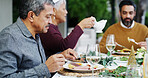 Family, dinner and old man with eating outdoor for thanksgiving lunch, festive celebration or social gathering. Food, people or bonding together on patio with healthy feast, holiday brunch or support