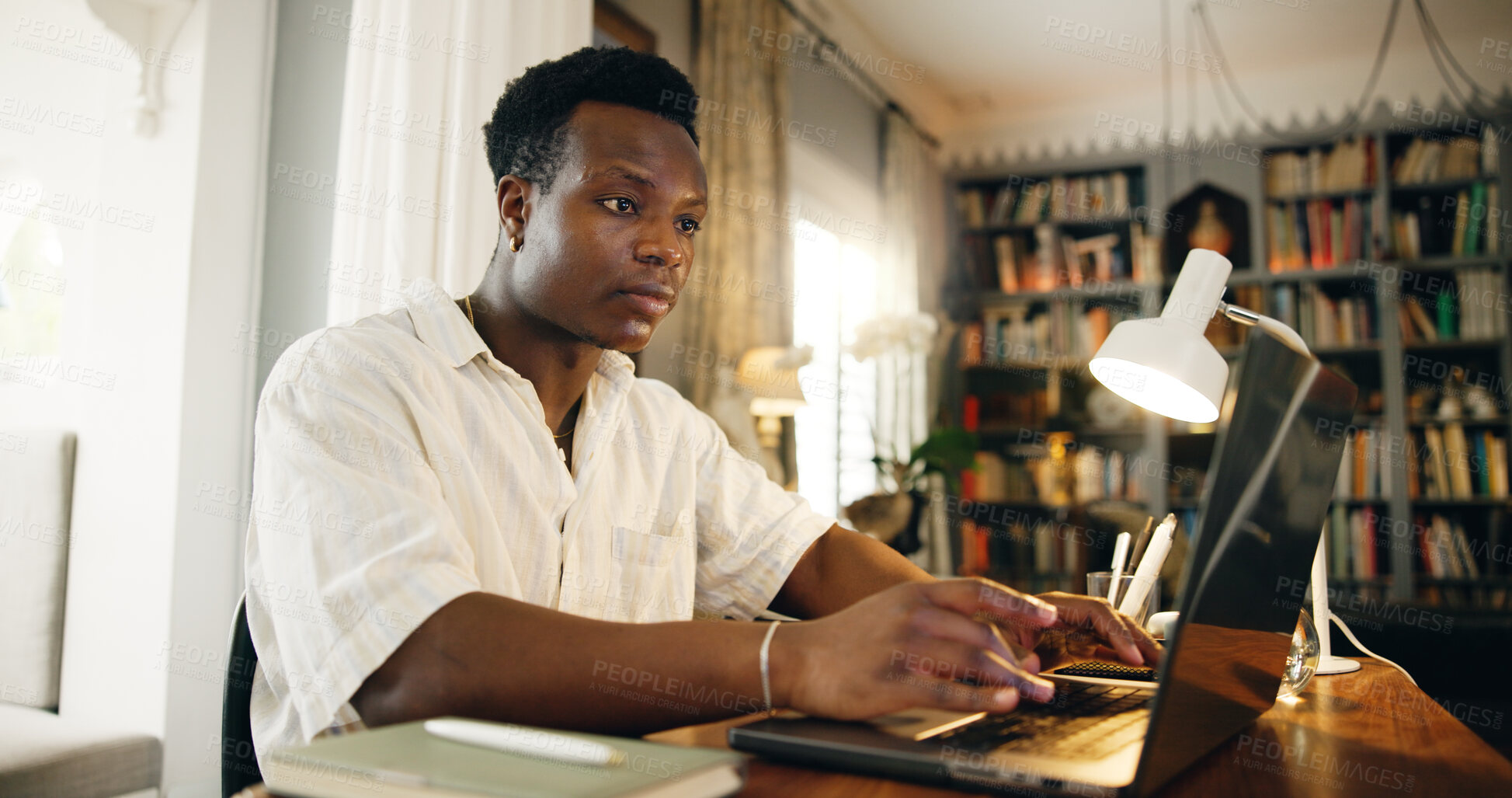 Buy stock photo Black man, e learning and typing on laptop, home and reading with studying, development and research in library. Person, computer and music with education, project and online course at apartment