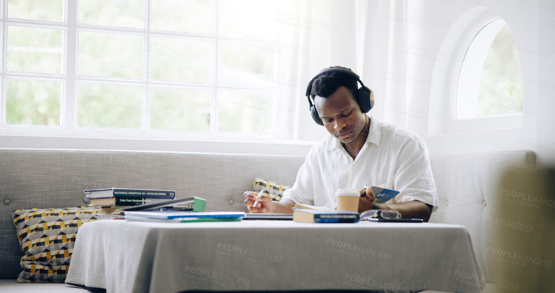 Buy stock photo Black man, reading and headphones with studying in home with books, assessment or listening to music with scholarship. Person, student and streaming with notes, education or learning for college exam