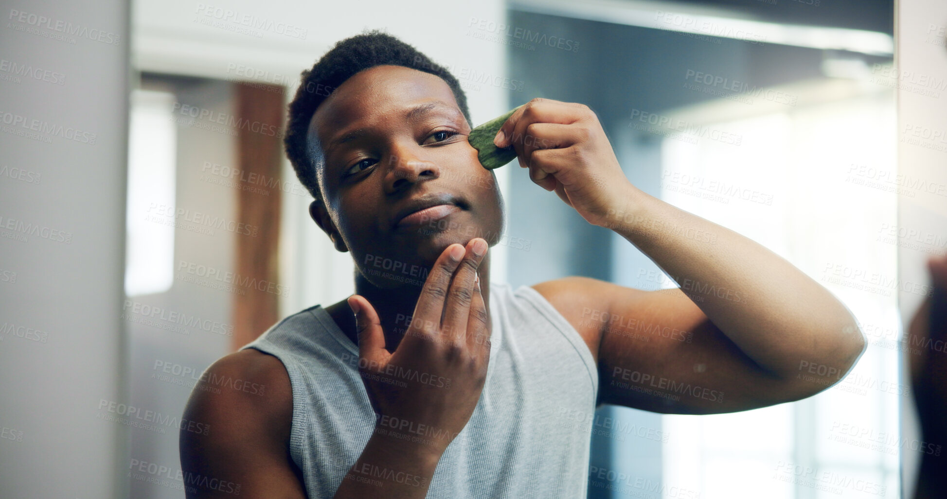 Buy stock photo Black man, gua sha and face with skincare for dermatology, facial or anti aging treatment at home. African, male person and beauty tool for hygiene, cosmetics or skin routine in bathroom at house