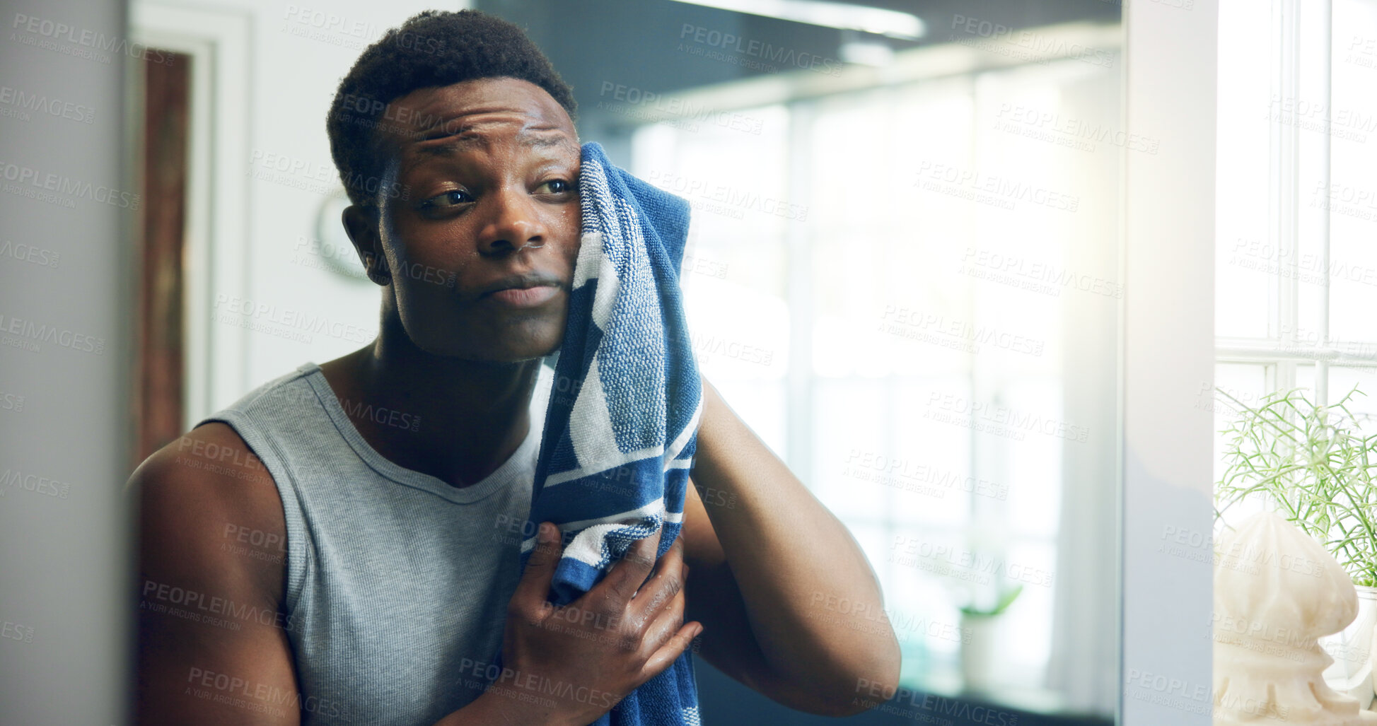 Buy stock photo Man, towel and mirror for skincare in home, bathroom and dry face for routine, grooming and process. African person, cloth and cleaning with facial transformation, change and cosmetics at apartment