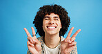 Happy man, peace sign and eyes closed with positive, expression for funky or hipster attitude on a blue studio background. Male person, young model or smile with emoji or finger gesture for V symbol