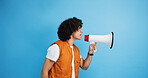 Man, profile and protest with megaphone in studio for strike, announcement or message on a blue background. Male person, rebel or march with loudspeaker or bullhorn for awareness or alert on space