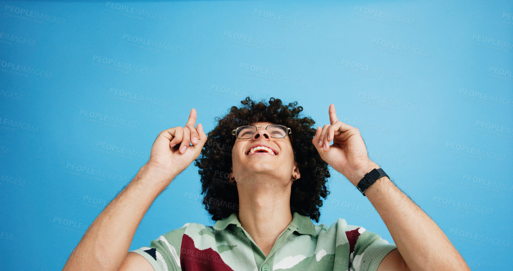 Buy stock photo Pointing up, smile and man with opinion, announcement and advertising in studio. Blue background, brand promotion and happy person with hand gesture, confidence and information in mockup space