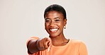 Portrait, pointing and smile of black woman in studio on grey background for choice, selection or vote. African girl, review and decision with happy person choosing you, gesture and emoji for opinion