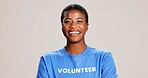 Black woman, portrait and smile as volunteer with pride, confidence and community service in studio. Female person, grey background and excited with NGO, charity and support for activism and help