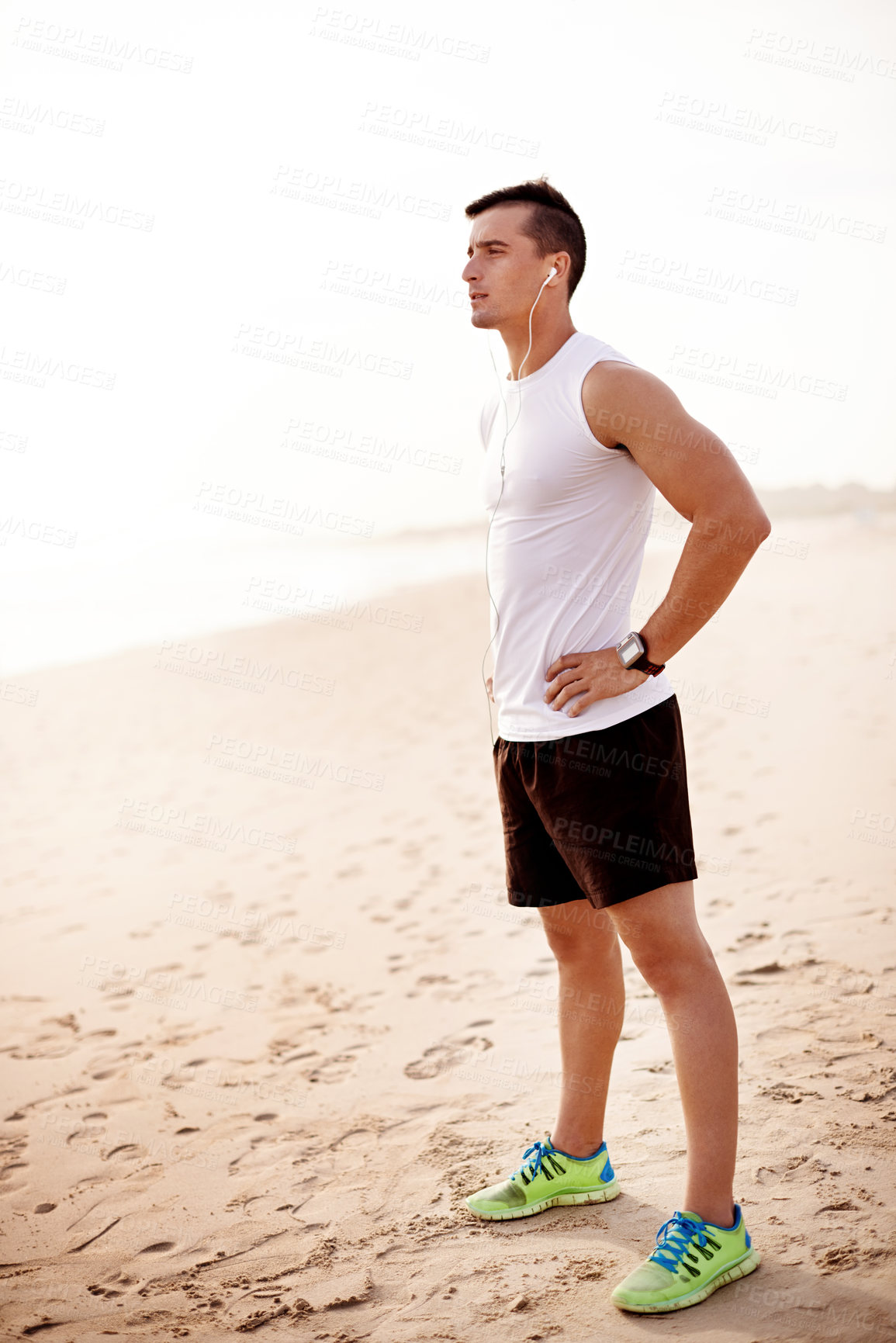 Buy stock photo Fitness, thinking and man on beach with earphones for streaming, outdoor workout and running in morning. Music, relax and runner at ocean with health, wellness and inspiration with exercise in nature