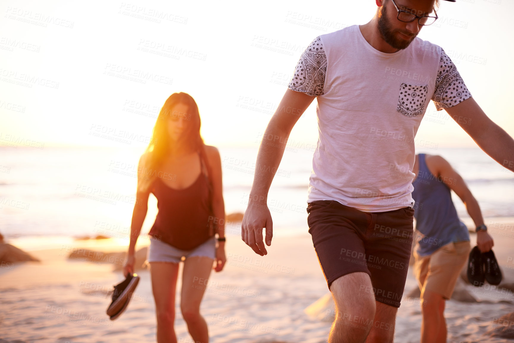 Buy stock photo Friends, sunset and walk at ocean for journey, summer holiday and study break at lens flare. People, students travel and vacation in Australia for adventure, outdoor trip or peaceful weekend at beach
