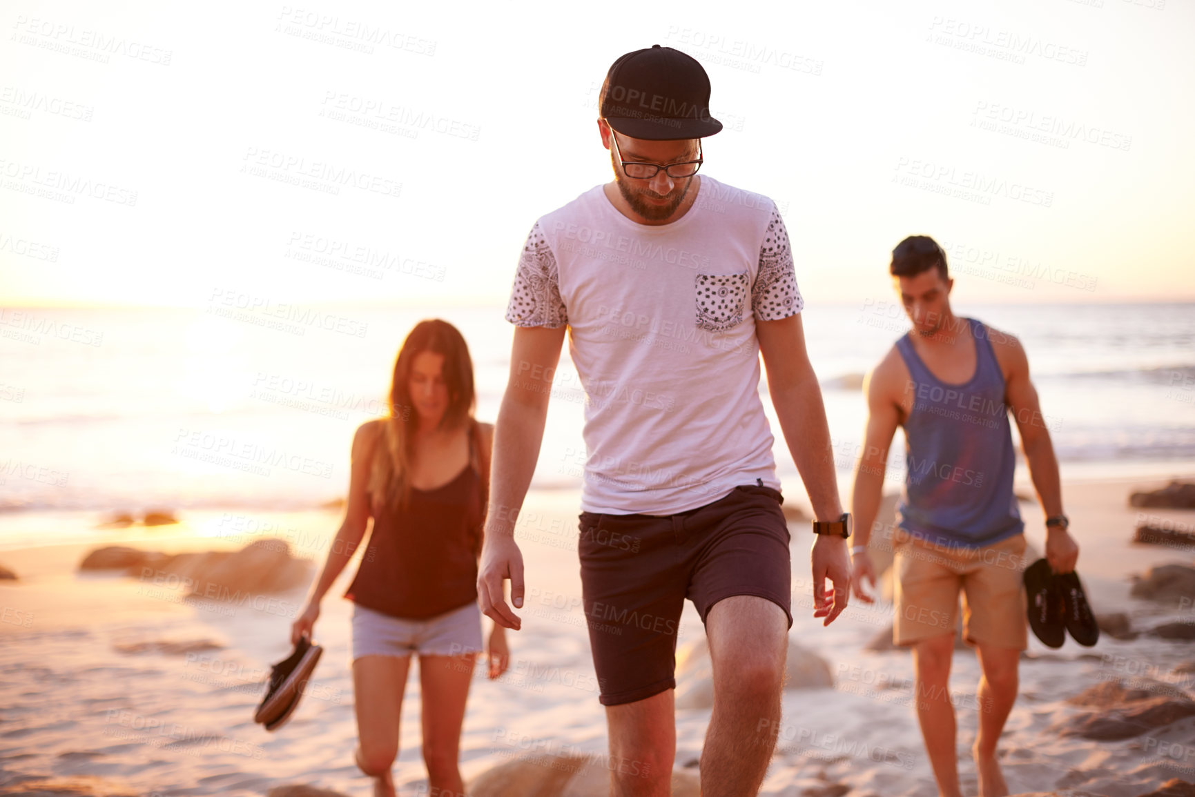 Buy stock photo Friends, sunset and walk on beach for travel, summer holiday and journey at day end. People, students bonding and vacation with sky space for adventure, outdoor trip and peaceful study break at ocean