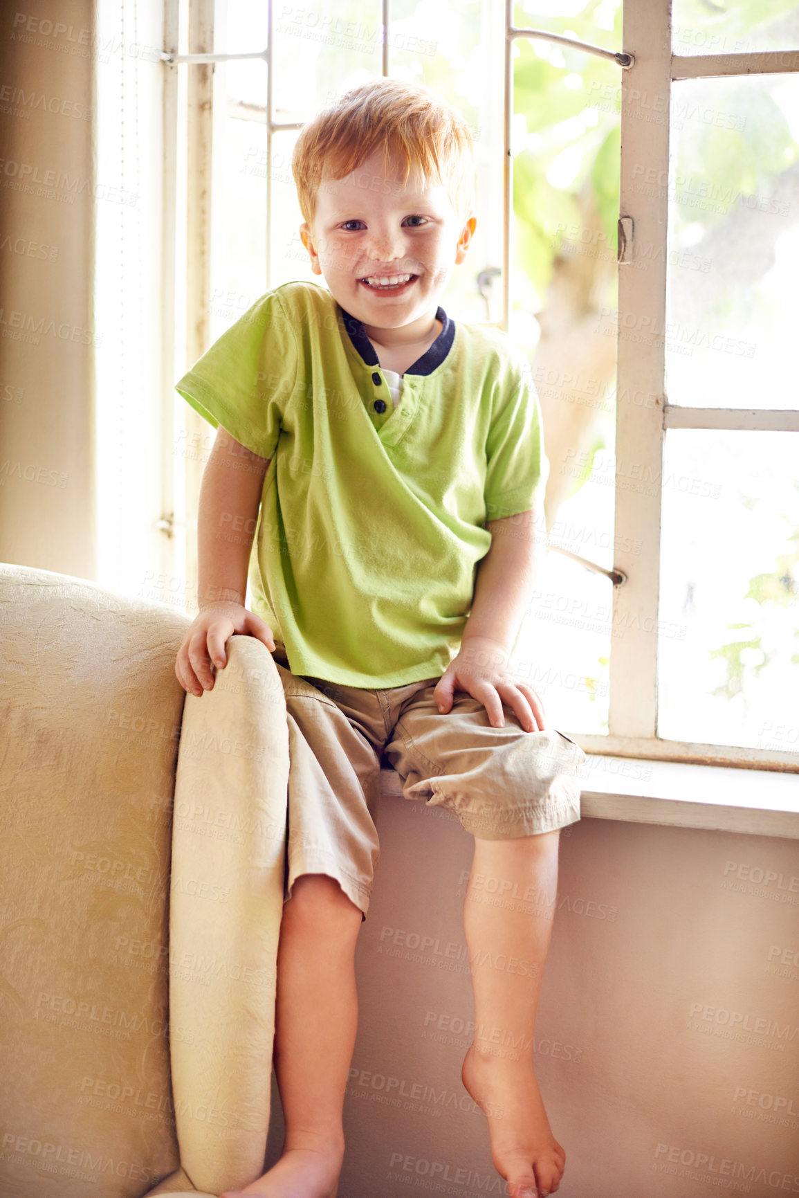 Buy stock photo Portrait, happy child and boy in home for relax, weekend and break in living room. Cute redhead, young kid and smile in house to chill by window, adorable and growth for development in New Zealand