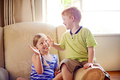 Buy stock photo Smile, children and sofa with high five at house of sibling agreement, playful games and bonding together. Happy, kids and affection with family relationship, connection and fun celebration in lounge