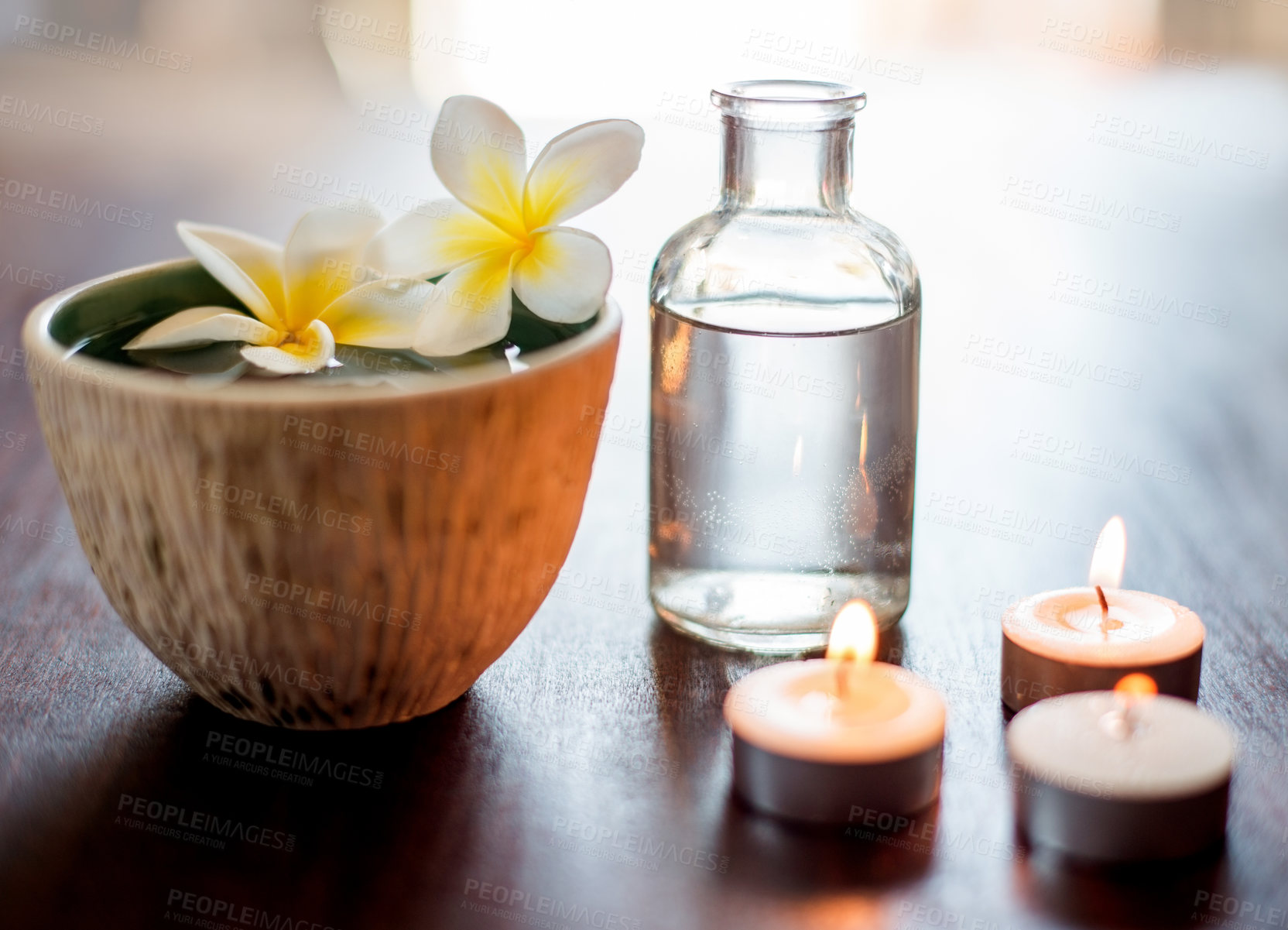 Buy stock photo Flower, spa and aromatherapy candles on table with water bowl, peace and natural fragrance. Holistic health, hospitality service and counter with essential oil for self care at luxury wellness salon