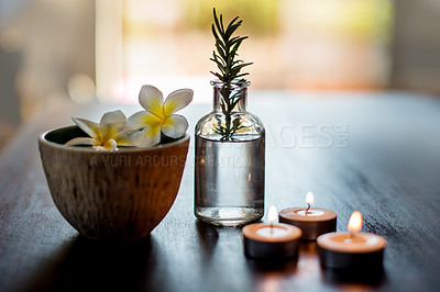 Buy stock photo Table, spa candles and essential oil with flowers for aromatherapy massage, luxury treatment and relaxation. Interior decoration, health clinic and empty room with organic products for stress relief