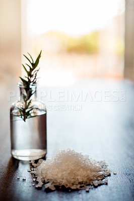 Buy stock photo Spa, wellness and rosemary essential oil with salt on table for aromatherapy treatment or luxury swedish massage. Space, health clinic and empty room with natural setup, organic products or self care