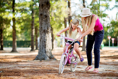 Buy stock photo Mother, girl and teaching with bicycle in park with love, bonding or happy in woods on holiday. Mama, kid and learning, cycling and bike on outdoor adventure, forest or vacation trail in nature