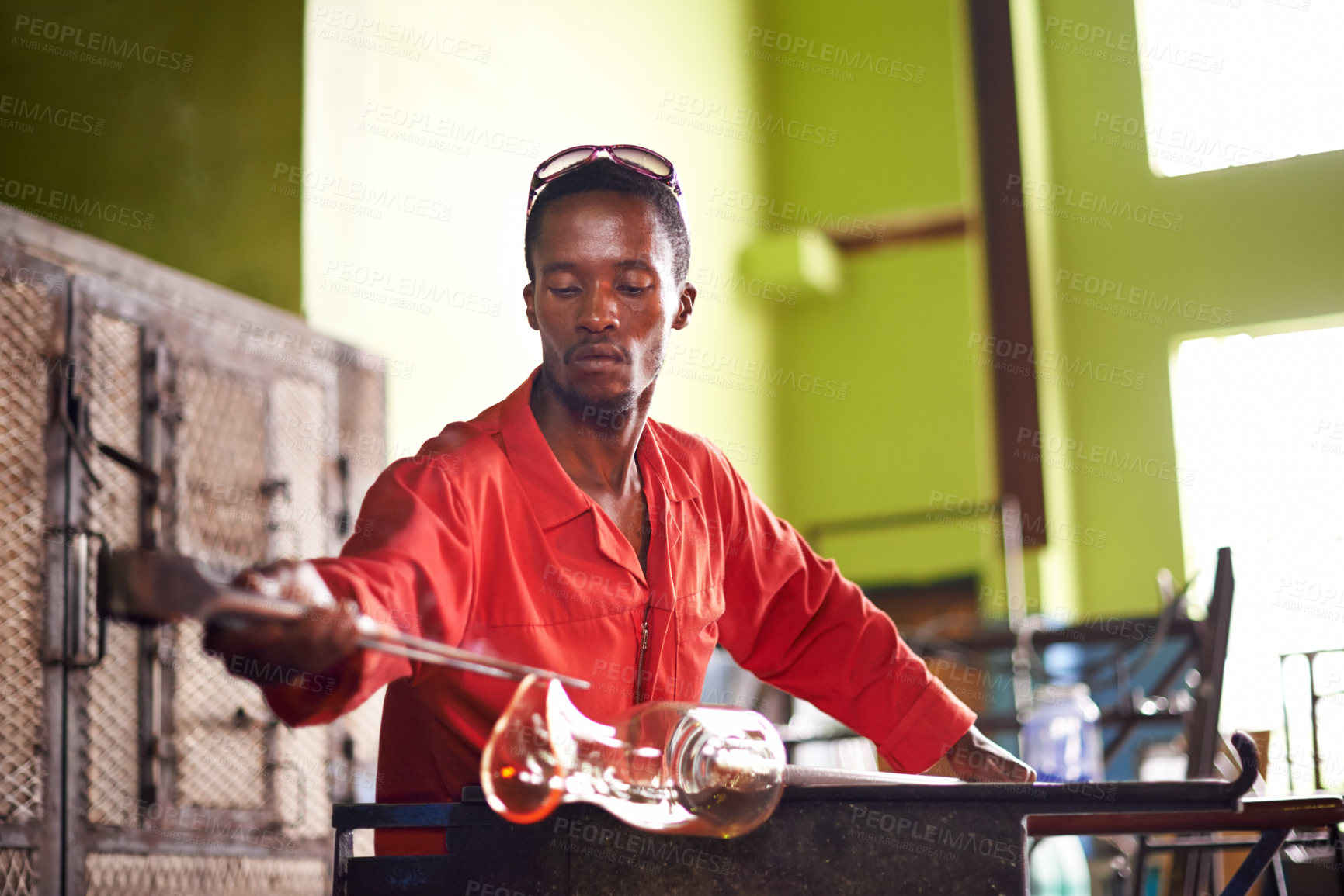 Buy stock photo Glass, blowing and black man in workshop for small business with creativity, tools and technique. Craft, product and glassblower in factory with sustainable art, design and bottle sculpture process